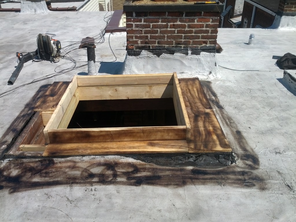 Reader Roofing framing out a skylight on a commercial building roof.