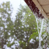 During heavy rain, water comes from over gutters requiring spring gutter maintenance.